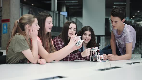 Five Children working with small robot at school