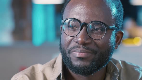 Bearded African American man clinking glasses and drinking beer