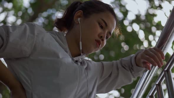 Asian girl fitness runner sportswomen tired after running in park sun outdoors.