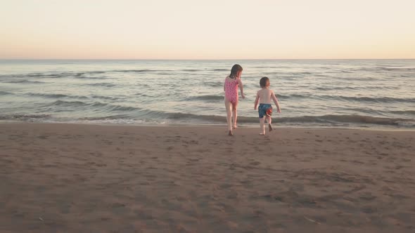 Young Sister and Brother Who Are Playing in the Sea