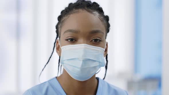 Portrait of Afroamerican Woman Doctor Female in Medical Protective Mask Looking to Camera alt