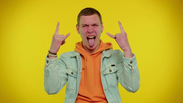 Overjoyed Teen Man Showing Rock n Roll Gesture By Hands Cool Sign Shouting Yeah with Crazy Face alt