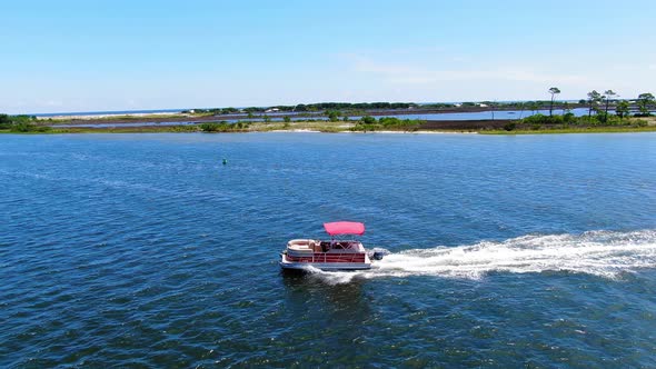Drone shot of a pontoon boat cruising through the Okaloosa sound next to Destin in northwest Florida alt