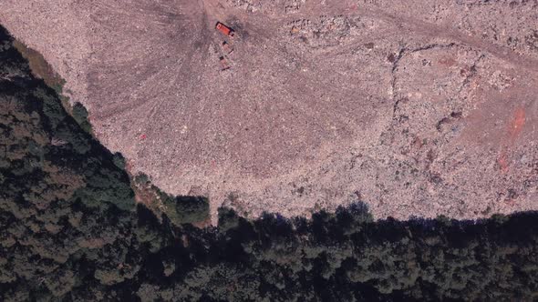 Descent Over the Landfill on the Border with the Forest, Over Which Birds Fly and Machinery Works