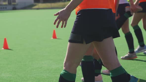 Female hockey players exercising on the field alt