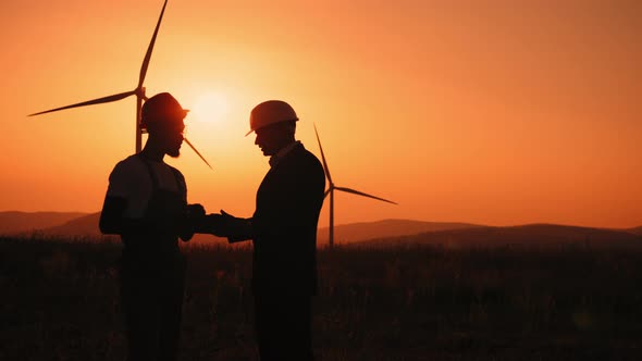 Silhouette Coworkers Examining Wind Turbines Using Modern Tablet Outdoors alt