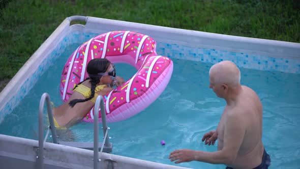 Little Girl and Happy Grandfather Having Fun Together in Outdoors Swimming Pool Granddaughter