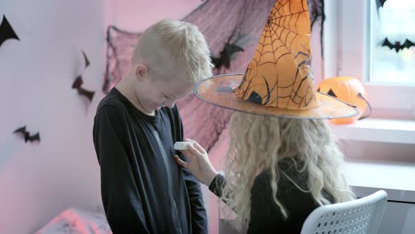 Halloween Kids Brother and Sister Preparing to Halloween Put on Costume at Home alt