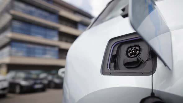 Hand closing the lid of an electrical car, after charging