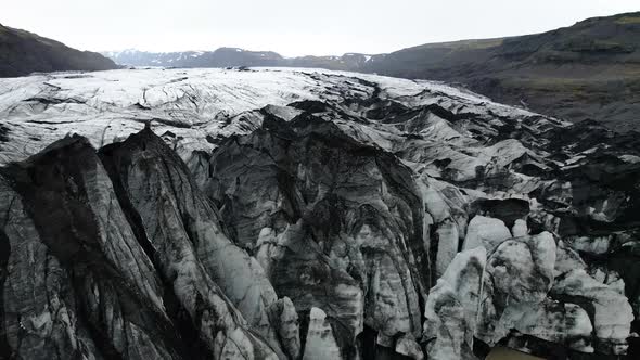 Iceland Glacier Drone flying above edge of glacier where it meets glacial lagoon alt
