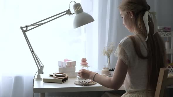 Young designer girl creates beautiful jewelry and embroidery patterns on fabric alt