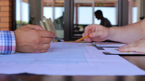 A meeting of two civil engineers to discuss the construction drawings of a business center. alt