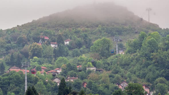 Houses on a hill with cable car moving up and down from Sarajevo station to mountains alt