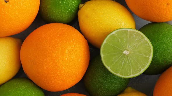 Half Cut Juicy Lime on Citrus Fruit Background, a Lot of Lemon, Oranges and Limes Top View alt