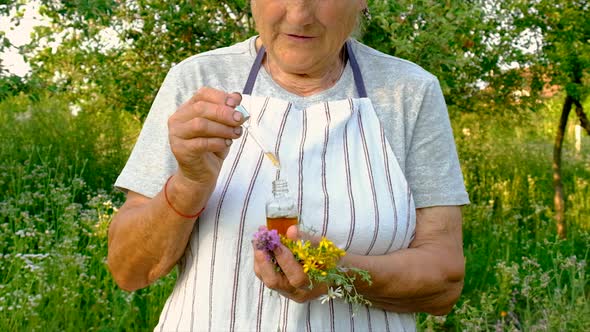 Old Woman Makes Herbal Tincture alt