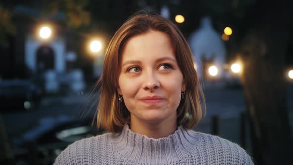 Close up portrait of a smartly young woman smiling and looking into the camera. alt