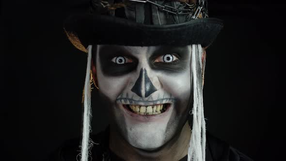 Creepy Man Face in Skeleton Halloween Cosplay Appearing on Black Background. Making Faces, Smiling alt
