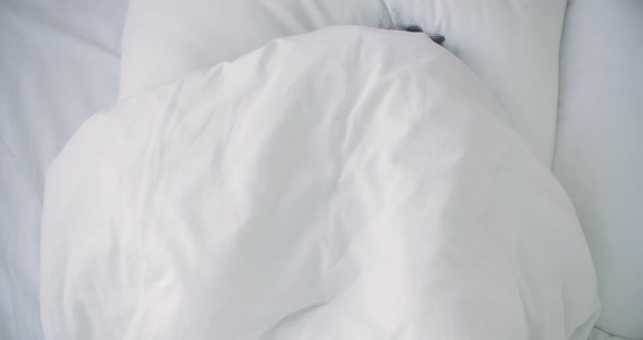 Woman Peeking Under Duvet and Smiling. Smiling Cheerful Woman Peeking Out From Under the Blanket in alt