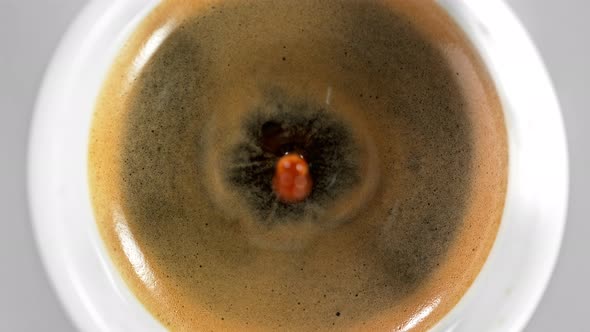 Super Slow Motion Detail Shot of Coffe Drop Falling Into Fresh Espresso at 1000 Fps. alt