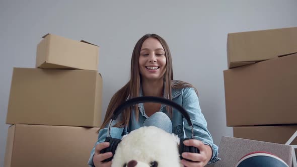 Joyful Woman which Fooling with Teddy Toy in Her New Flat After Moving alt