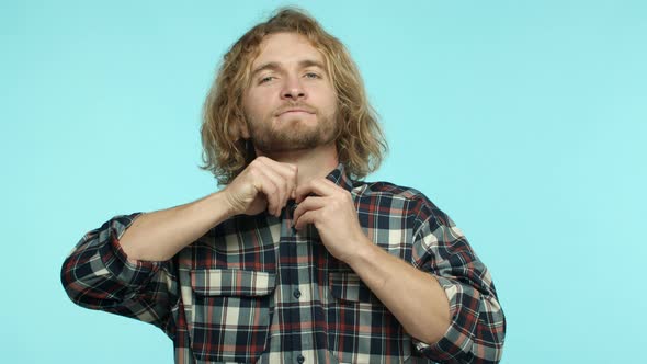 Slow Motion of Attractive European Man with Beard and Long Blond Wavy Hair Getting Dressed Button Up