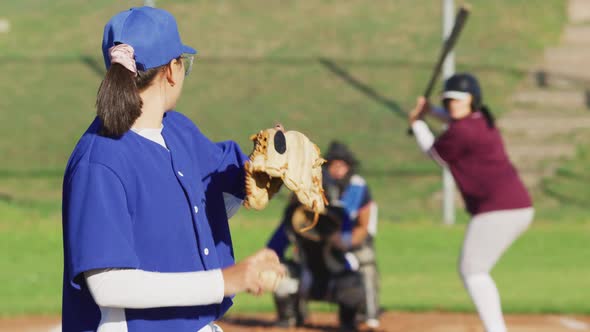 Diverse group of female baseball players in action on the field, pitched ball caught by catcher alt