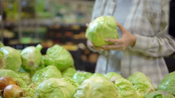 Woman in Protective Mask Choosing Cabbage in Supermarket