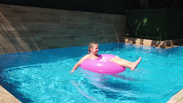 Girl Floating on Pink Inflatable Ring and Diving Under Water