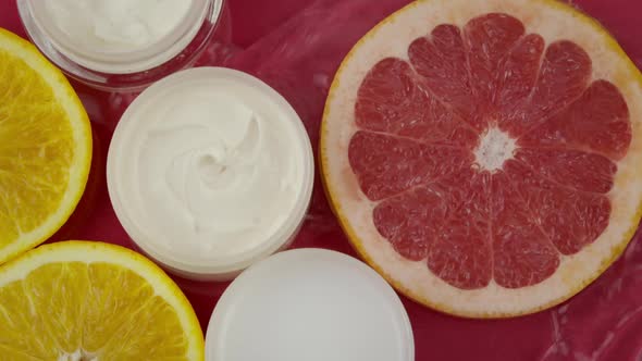 Cosmetic Jars with Moisturizing Cream Pieces of Citrus Fruits in Water Splash