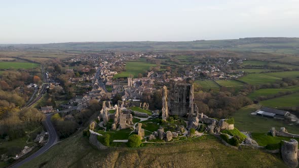 Corfe Castle at twilight, County Dorset in United Kingdom. Aerial approach alt