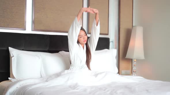 Asian woman relax on bed in bedroom interior