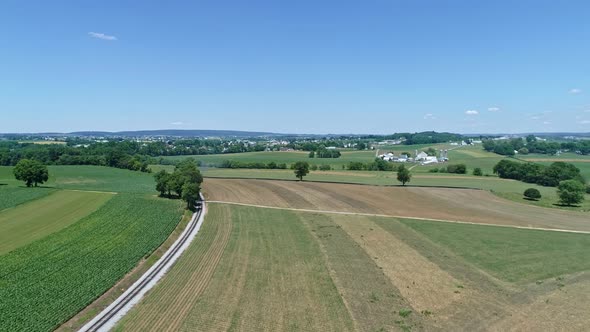 Aerial View of the Farm Countryside with a Single Rail Road Track on a Curve alt