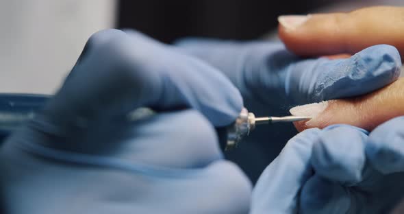 Cuticle removing with electrical tool, nail care and cleaning, polish process. Close-up of manicure