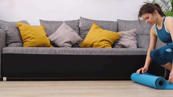 Beautiful Athletic Woman Laying Out a Mat for Sports