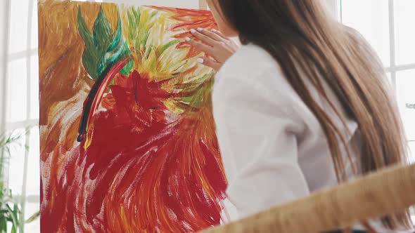 Woman Artist Draws Exotic Flower Touching Canvas By Finger alt