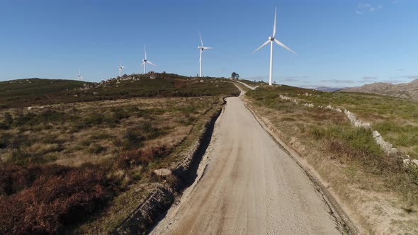 Dirty Road with Windmills on Mountains alt