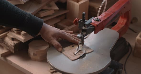 Woodworking at the Workshop Carpenter Uses Automatic Jigsaw and Cuts Small Plywood Parts alt