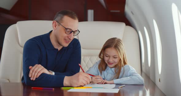 Father and Daughter Drawing with Colorful Pencils Flying Together on Private Jet alt