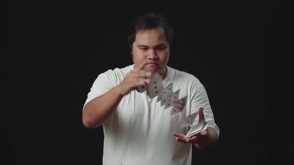 Asian Magician Does Card Trick Throwing Deck From One Hand To Another. Slow Motion alt