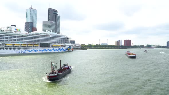 View from bridge on port of Rotterdam with small boats passing by alt