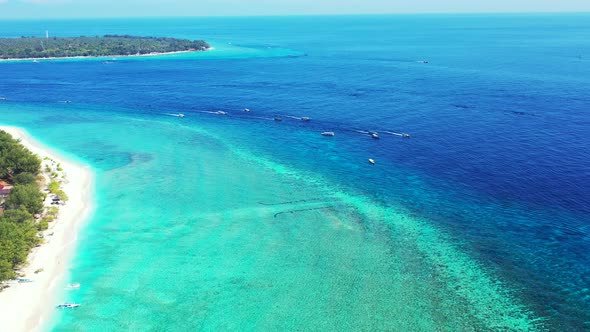 Wide angle flying copy space shot of a sandy white paradise beach and aqua blue water background in  alt