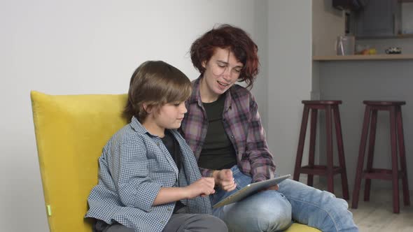 Mother Showing Son How Use Digital Tablet
