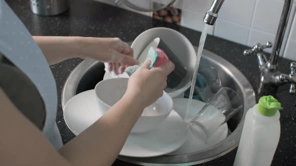 Female Hands Washing Dishes in Kitchen Sink alt
