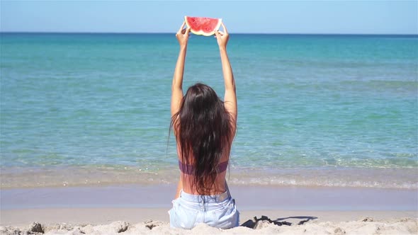 Happy Girl Having Fun on the Beach and Eating Watermelon