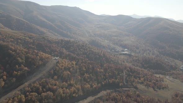 Flying over beautiful mountains in Bakuriani. Aerial view of Autumnal forest. Georgia alt