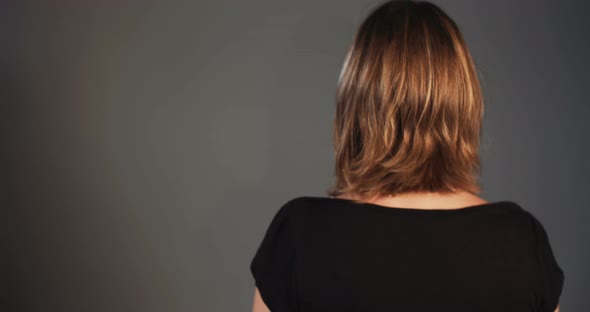 Young beautiful blonde woman making happy expressions on dark background alt