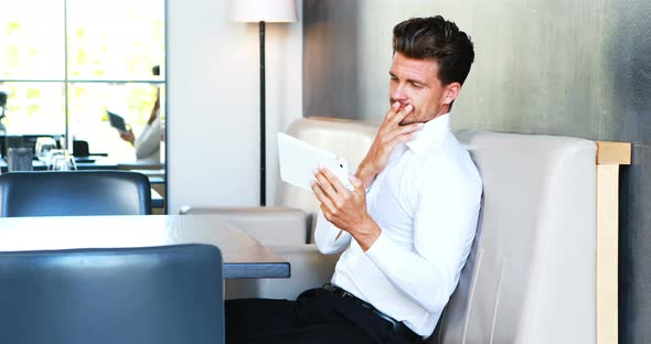 Smiling man using digital tablet alt