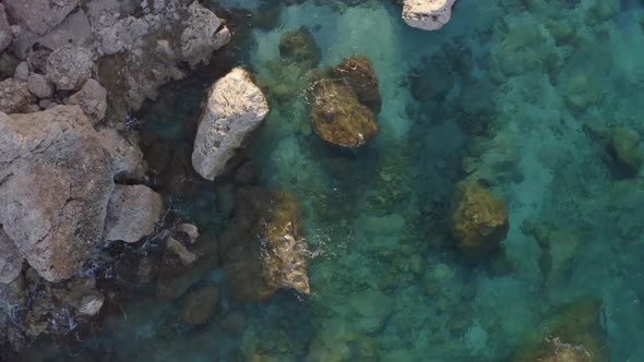 Aerial View of Rocky Shore with Turquoise Ocean Water alt