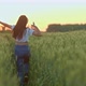 Happy Young Woman is Running on Field of Rye or Wheat in Sunset Rear View  Prores - VideoHive Item for Sale