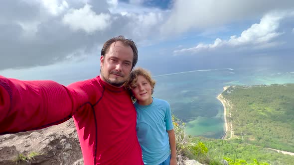 A Man and His Son Take a Selfie on Mount Le Morne Mauritius alt